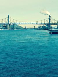 Suspension bridge over sea against clear sky