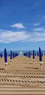 Panoramic view of row on beach against blue sky