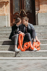 Valentines day celebration and dating concept. happy loving couple with red love balloons 