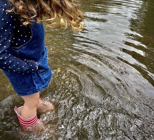 Low section of woman standing in water