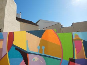 Low angle view of multi colored building against clear blue sky