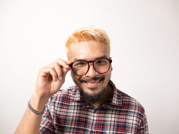 Portrait of man wearing eyeglasses against white background