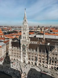 Aerial view of city buildings against cloudy sky
