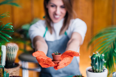 Female gardener holding a potted plant