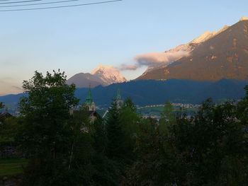 Scenic view of trees and mountains against sky