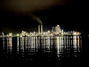 Illuminated city against sky at night