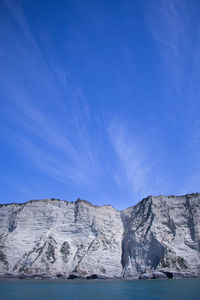 Scenic view of sea and rocks against blue sky