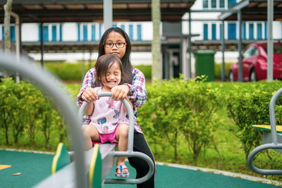 Kids playing at the see-saw in the playground. siblings play together.