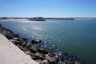 Calm sea against clear blue sky