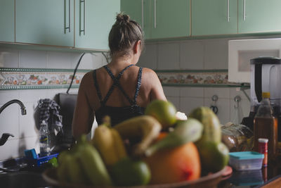 Caucasian woman with her back to her cooking in the kitchen. 