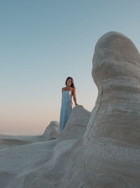 Woman standing on beach against clear sky