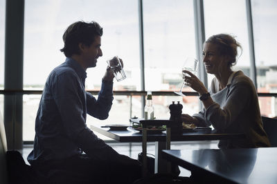 Man and woman sitting on table at window