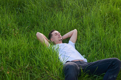 Young woman sitting on grassy field