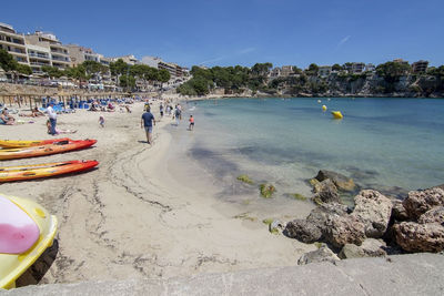 People on beach by sea against sky