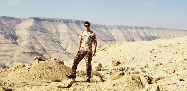 Full length of man standing on rocky mountain