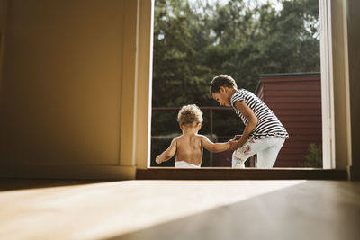 Siblings seen through open door