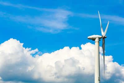 Low angle view of wind turbine against blue sky