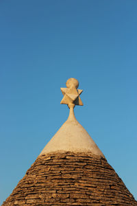 Low angle view of sculpture against blue sky