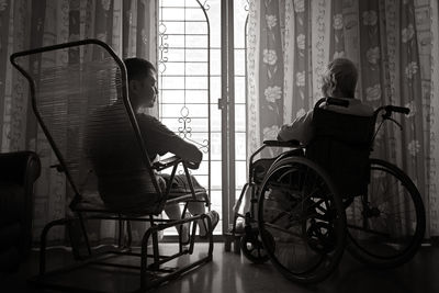 Rear view of men sitting by window