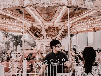 People looking at carousel in amusement park