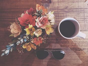 Directly above shot of flowers vase and coffee cup on table