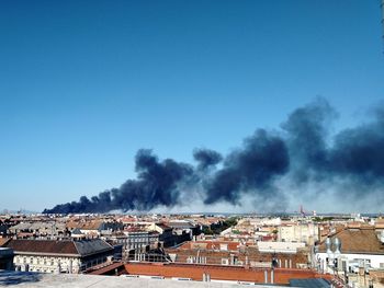 A burning building in town against clear blue sky