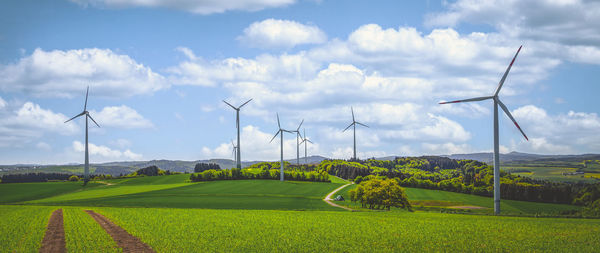 Wind turbines on agriculture field under cloudy sky