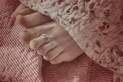 Midsection of woman relaxing on bed