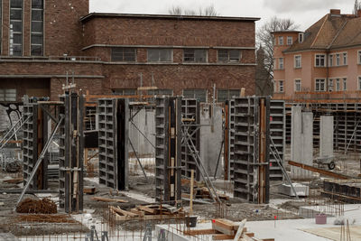 Old building by construction site in city