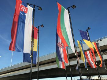 Low angle view of flags against blue sky