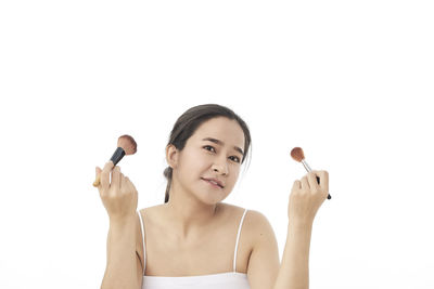 Portrait of young woman against white background