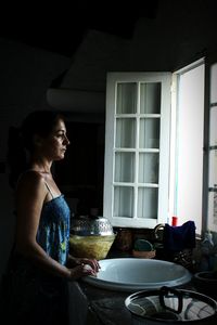 Close-up of young woman standing in kitchen