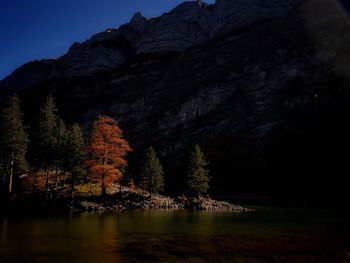 Scenic view of river by mountain against sky