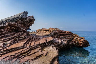 Rock formations in sea against sky