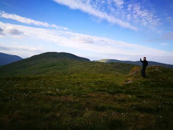 Man standing on field against sky