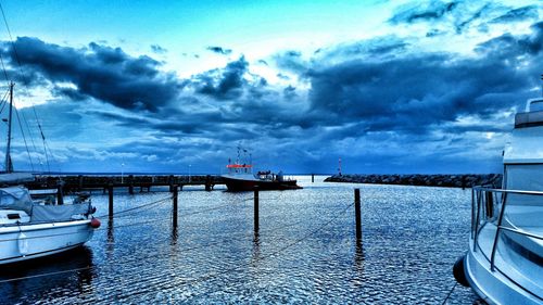 Pier on sea against cloudy sky