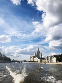 Buildings in city against cloudy sky