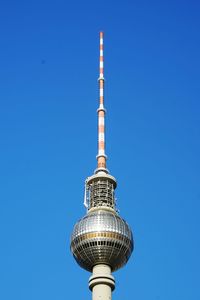 Low angle view of communications tower against blue sky