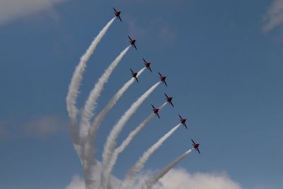 Low angle view of airshow against sky