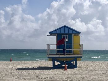 Lifeguard hut on beach against sky