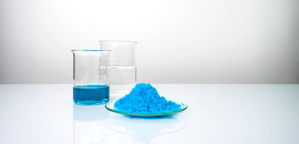 Close-up of glasses on table against white background