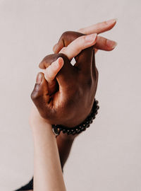 Close-up of hand holding hands against white background