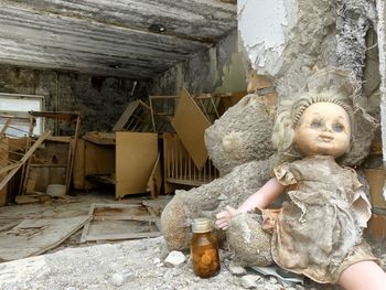 Young woman sitting on abandoned toy in building