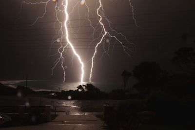 Lightning over sea against sky at night