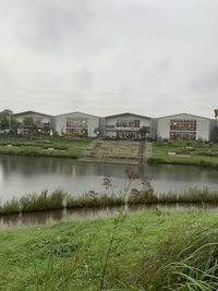 Scenic view of lake by buildings against sky