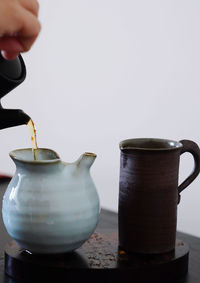 Cropped hand of woman pouring tea from teapot