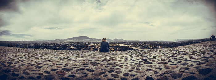 Woman standing on sand at beach against sky