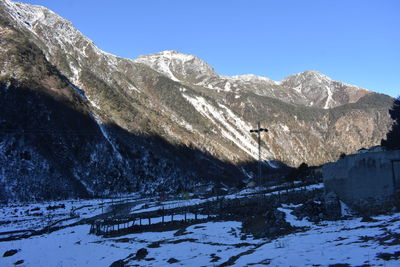 Scenic view of snowcapped mountains against clear blue sky