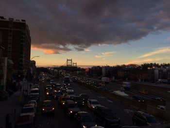 High angle view of traffic on road against buildings at sunset