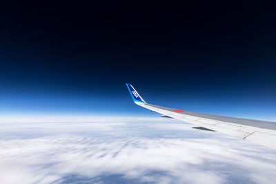 Aerial view of airplane wing against cloudy sky